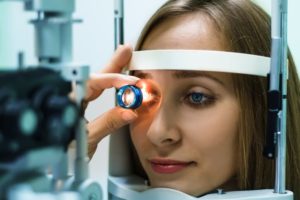 A woman examining her eye during an eye exam. Eye health is closely linked to brain health. Wholesale Optical Frames