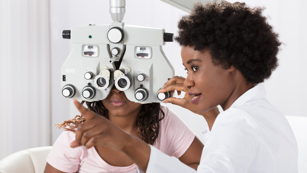 A woman at a Wholesale Optical Lenses Laboratory gazes at an eye exam machine, ensuring precise vision testing.