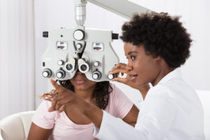 A woman at a Wholesale Optical Lenses Laboratory gazes at an eye exam machine, ensuring precise vision testing.