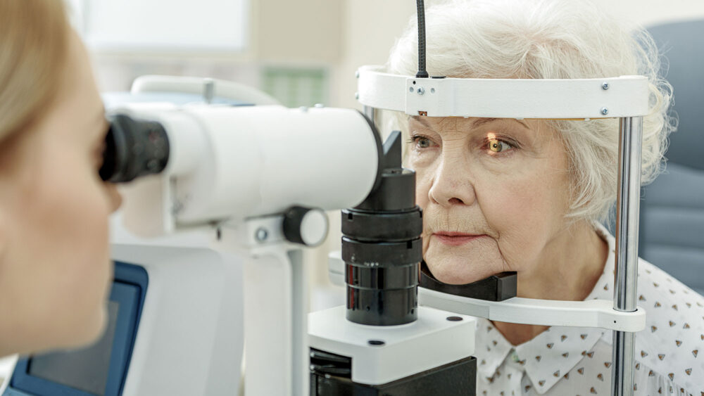 An older woman getting her eyes checked at an eye exam. Optics Suppliers Pennsylvania.