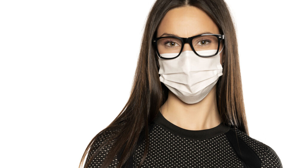 A woman wearing a mask and glasses, taking precautions. Optics Suppliers Pennsylvania.