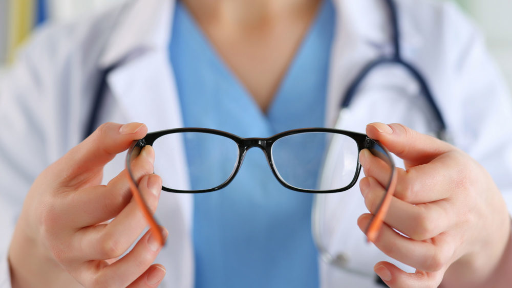 A doctor from Optics Suppliers Pennsylvania holds a pair of glasses, ready to provide clear vision.