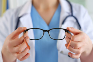 A doctor from Optics Suppliers Pennsylvania holds a pair of glasses, ready to provide clear vision.