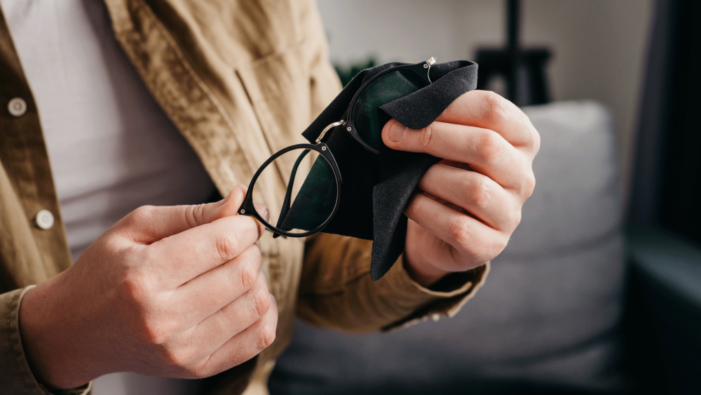 A man holding a pair of glasses in an Optical Laboratory.