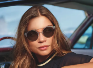 A stylish woman rocking sunglasses in a car, looking cool and ready to hit the road. #WholesaleOpticalLenses