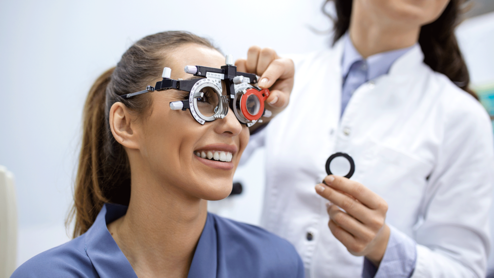 A woman happily wearing an eye exam with optical lenses, showcasing her beautiful smile.